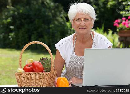 Closeup of elderly woman in garden with basket of fresh vegetables