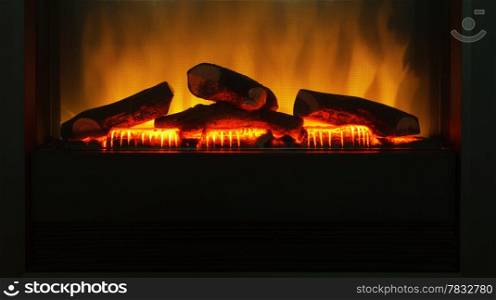 Closeup of electric artificial fireplace with orange fire flame interior