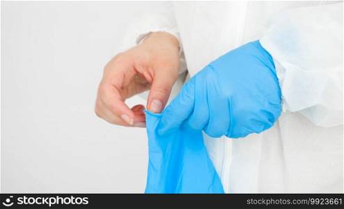 Closeup of female doctor hands wearing protective rubber gloves. Global fight and protection against covid-19 and coronavirus.. Closeup of female doctor hands wearing protective rubber gloves. Global fight and protection against covid-19 and coronavirus