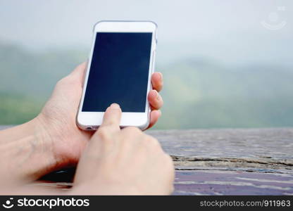 Closeup of female hand using a smart phone. Shallow depth of field