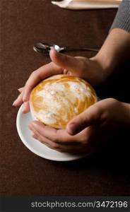 Closeup of female hands holding cup of Cappuccino