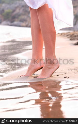 closeup of female legs on sunrise beach