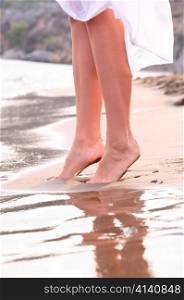 closeup of female legs on sunrise beach