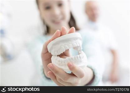 Closeup of girl showing dentures at dental clinic
