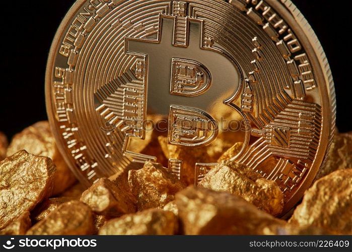 Closeup of gold nugget and Gold Bitcoin Coin on black background . Bitcoin as desirable as digital gold concept. Bitcoin cryptocurrency.. Closeup of gold nugget and Gold Bitcoin Coin on black background.