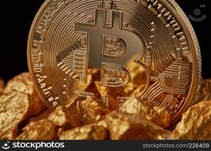 Closeup of gold nugget and Gold Bitcoin Coin on black background . Bitcoin as desirable as digital gold concept. Bitcoin cryptocurrency.. Closeup of gold nugget and Gold Bitcoin Coin on black background.