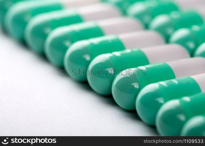 Closeup of green-white pills in a row