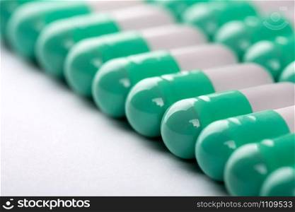 Closeup of green-white pills in a row