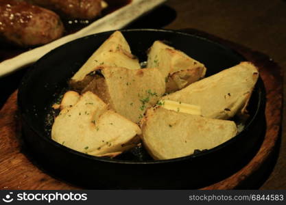 Closeup of grilled potato on hot fry pan