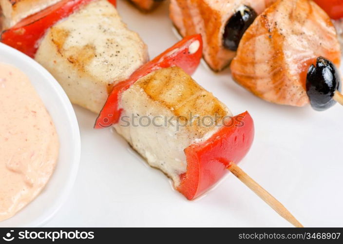 Closeup of grilled salmon and shrimps with tomatoes and peppers on bamboo sticks