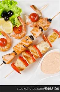 Closeup of grilled salmon and shrimps with tomatoes and peppers on bamboo sticks