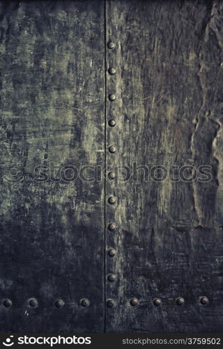 Closeup of grunge black metal plate with rivets and screws as background or texture