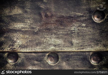 Closeup of grunge black metal plate with rivets and screws as background or texture