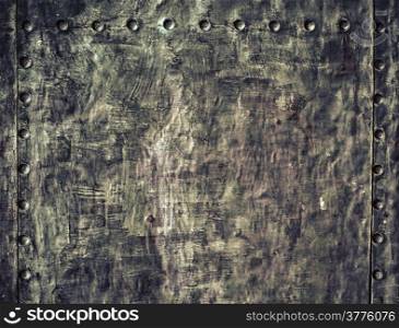Closeup of grunge black metal plate with rivets and screws as background or texture