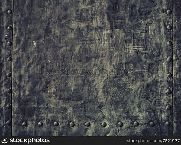Closeup of grunge black metal plate with rivets and screws as background or texture
