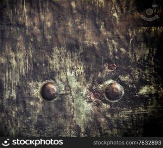 Closeup of grunge black metal plate with rivets and screws as background or texture. Square format.