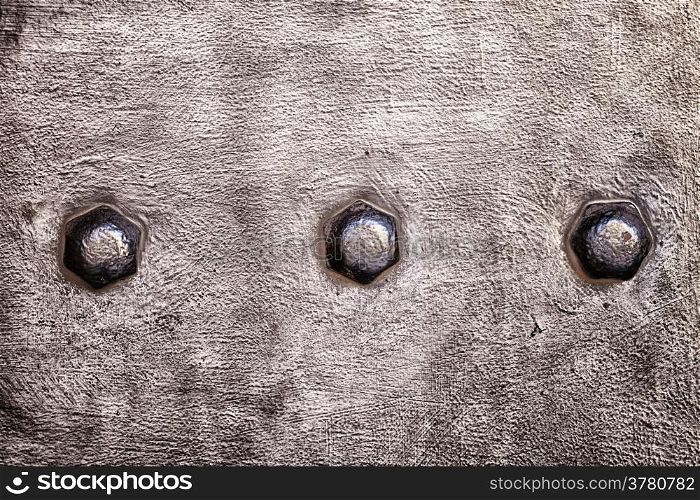 Closeup of grunge brown metal plate with rivets and screws as background or texture