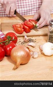 closeup of hands cutting tomatoes. closeup of hands preparing vegetables for italian food