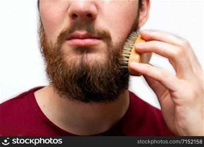 closeup of handsome man brushing his beard on white background isolated beauty. closeup of handsome man brushing his beard on white background isolated