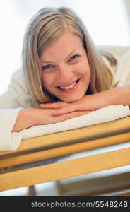 Closeup of happy woman lying on wooden bed at beauty spa