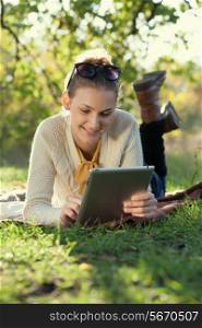 Closeup of happy woman using tablet computer outdoors