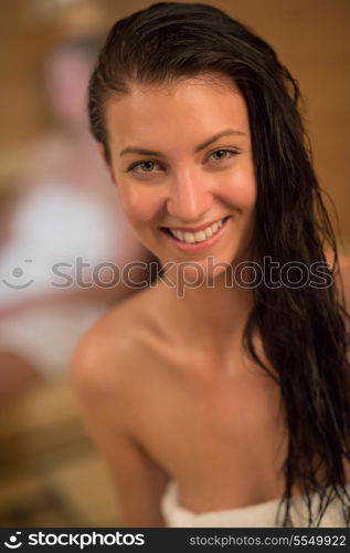 Closeup of happy young woman with wet hair in sauna