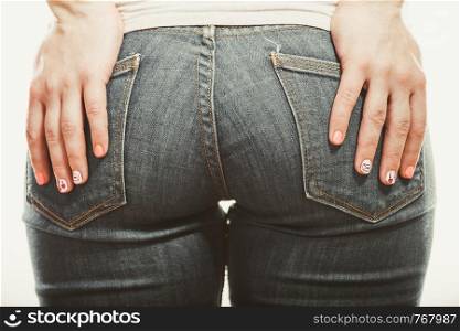 Closeup of human with hands palms on buttocks ass in jeans trousers.. Human with hands on buttocks ass in jeans trousers