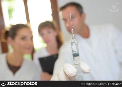 Closeup of hypodermic needle held by doctor