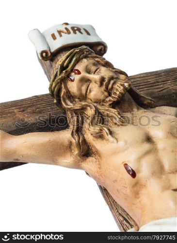 closeup of jesus crucified on the cross. image shows the face of jesus, part of the cross and the sign INRI