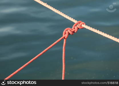 Closeup of knot on rope line over sea ocean water.. Knot on rope line over sea ocean water.