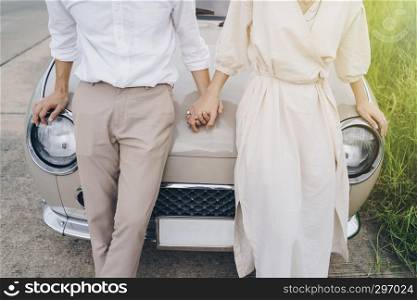Closeup of loving couple holding hands on road trip at sunset. Love, Valentine and wedding concept.