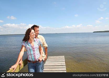 Closeup of loving couple standing on a pontoon by a lake