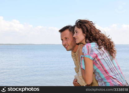 Closeup of loving couple standing on a pontoon by a lake