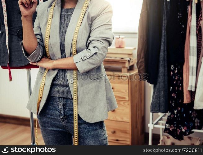 Closeup of lower body of fashion stylist designer in business owner workshop. Tailor and sewing concept. Portrait of happy casual trendy fashion designer businesswoman in studio. Job and occupation