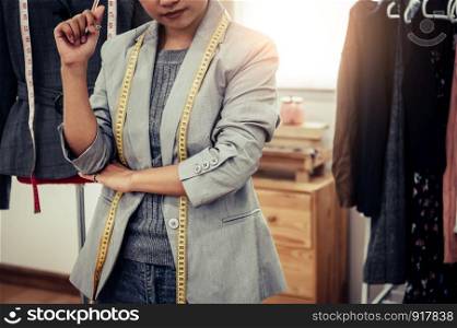Closeup of lower body of fashion stylist designer in business owner workshop. Tailor and sewing concept. Portrait of happy casual trendy fashion designer businesswoman in studio. Job and occupation