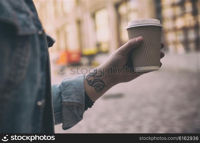 Closeup of male hand with coffee cup on street food festival