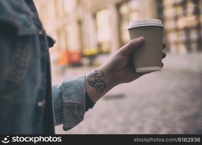 Closeup of male hand with coffee cup on street food festival