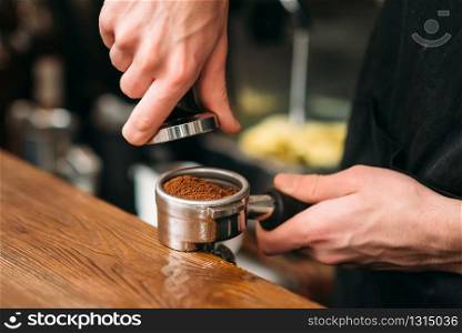 Closeup of male hands cooking coffee. Cafe on the background.