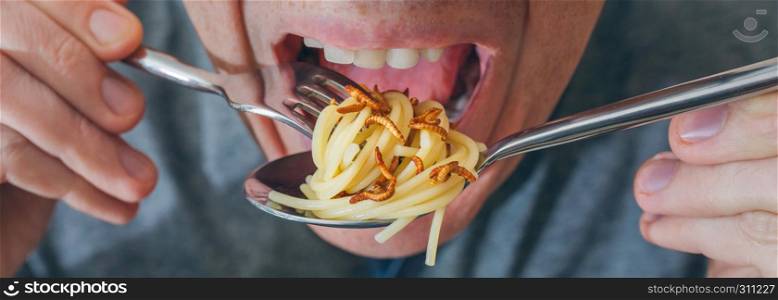 Closeup of man eating spaghetti with crispy worms. Man eating spaghetti with worms