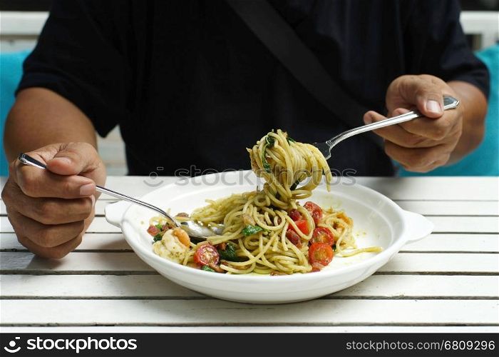 closeup of man hands holding fork and spoon during eating spaghetti