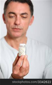 Closeup of man holding bottle of pills