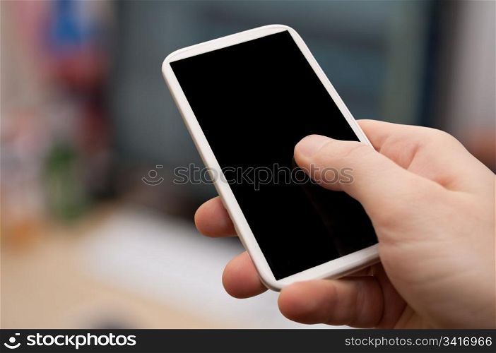 Closeup of Man&rsquo;s Hand Touching Screen of Smartphone in Office