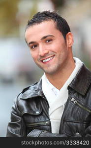 Closeup of man with leather jacket standing outside