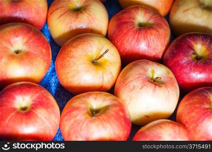 Closeup of many red-yellow juicy apple fruits in market. Many fresh natural organic apples candid shot.