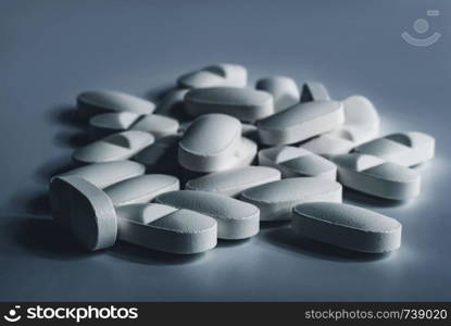 Closeup of many white prescription drugs, medicine tablets or vitamin pills in a pile - Concept of healthcare, opioids addiction, medicament abuse or medication treatment.. Closeup of many white prescription drugs, medicine tablets or vitamin pills in a pile - Concept of healthcare, opioids addiction, medicament abuse or medication treatment