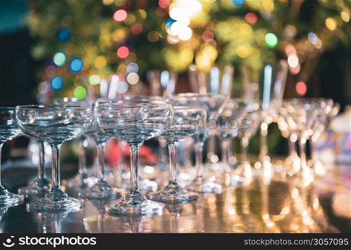 Closeup of martini glasses with alcoholic drinks on bar in night club with colorful bokeh background. Close up alcohol in pub restaurant. Food and beverage concept.
