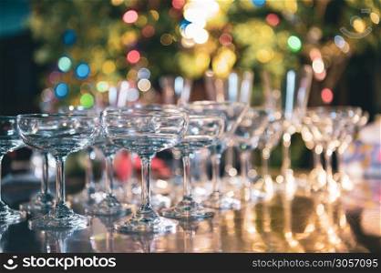 Closeup of martini glasses with alcoholic drinks on bar in night club with colorful bokeh background. Close up alcohol in pub restaurant. Food and beverage concept.