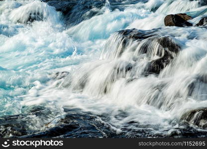 Closeup of Midfoss waterfall with its blue water in a sunny day, Iceland. Midfoss waterfall, Iceland