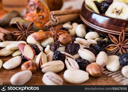 Closeup of mix of dried fruits in a wooden bowl and nuts over a rustic table. Closeup of mix of dried fruits and nuts