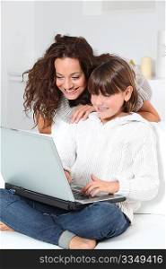 Closeup of mother and child at home with laptop computer